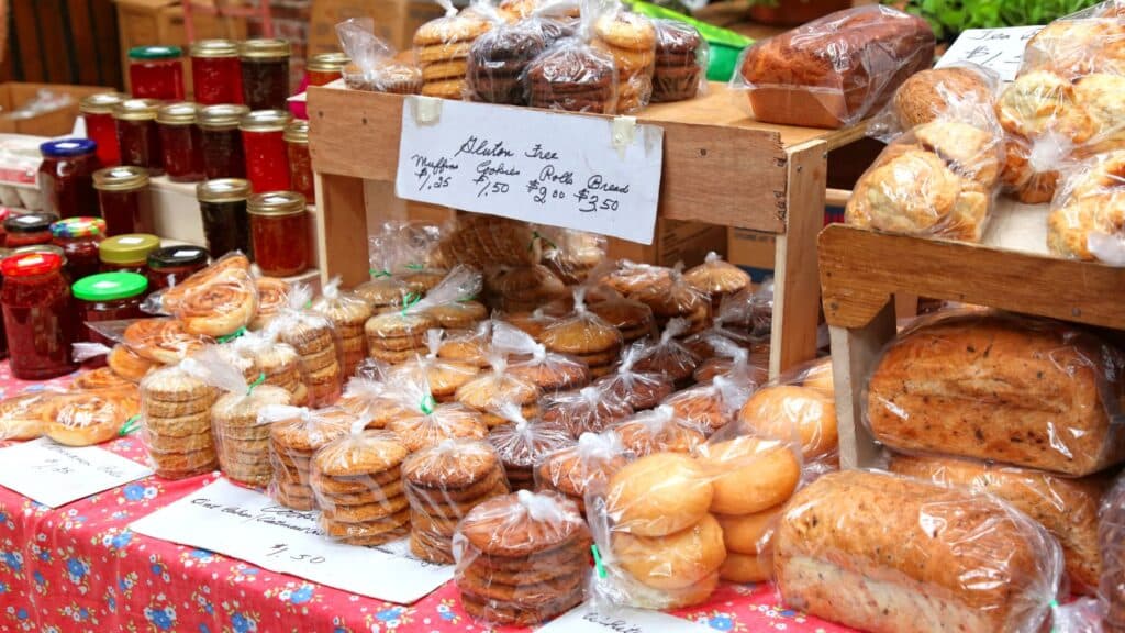 Assorted homemade breads and jams at a market stall.