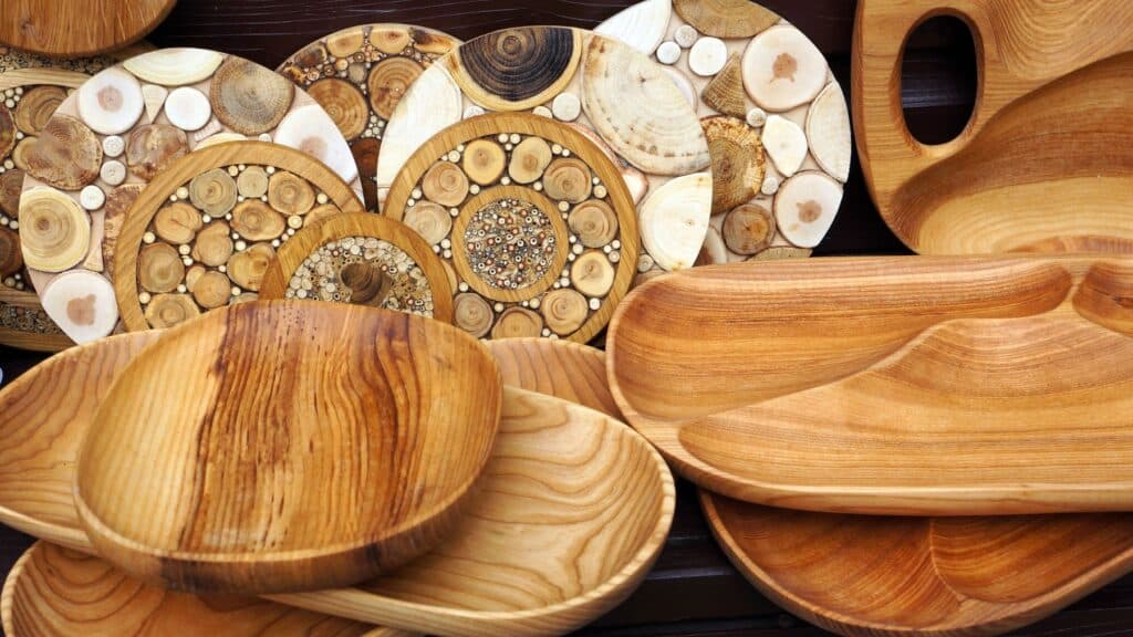 Assorted wooden bowls and art on wooden surface.