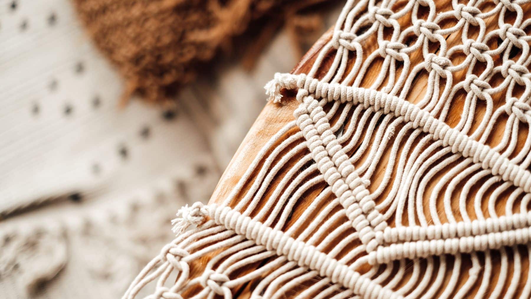 Close-up of macrame decor on wood.