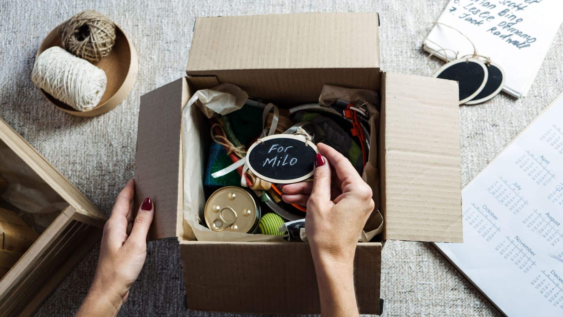 Hands organizing box of assorted items with label.